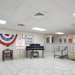 A spacious lobby featuring a piano and seating area, adorned with American-themed decorations.