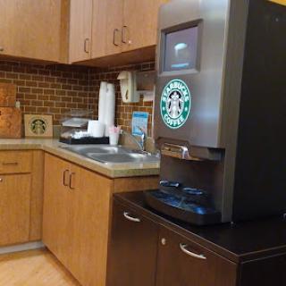 A coffee station featuring a Starbucks coffee machine in a cozy kitchen setting.