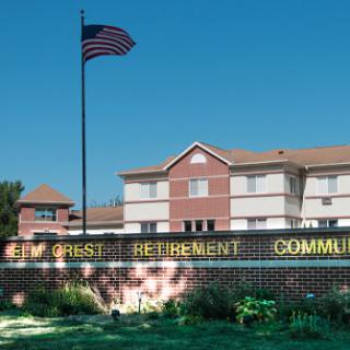 A retirement community featuring an American flag and a brick entrance sign.