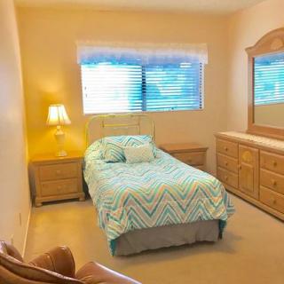 A cozy bedroom with a single bed and wooden furniture.