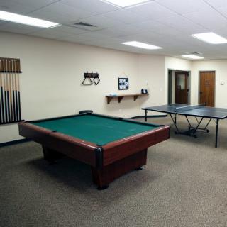 A spacious game room featuring a pool table and a ping pong table.