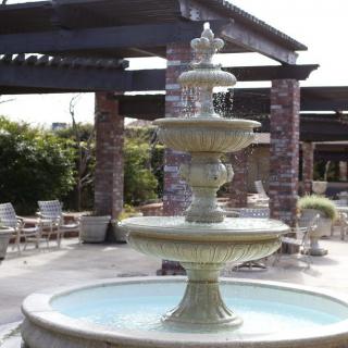 A beautiful multi-tiered fountain in an outdoor patio setting.