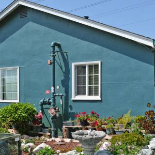 A blue house with a well-maintained garden in front.