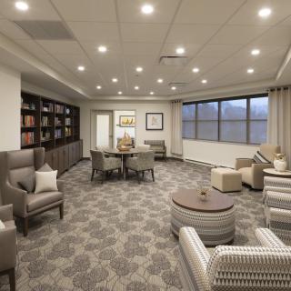 A modern lounge area with comfortable seating, bookshelves, and elegant lighting.