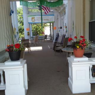 A serene porch adorned with colorful flowers and a welcoming American flag.