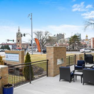 A view of a cityscape with outdoor seating and buildings in the background under a clear blue sky.