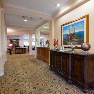 A well-decorated lobby area with furniture and a painting on the wall.
