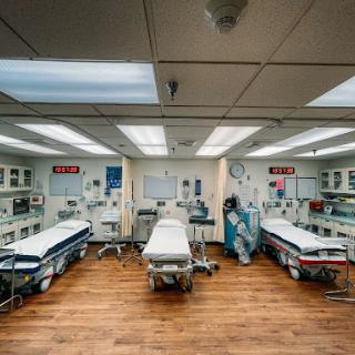A spacious emergency room equipped with multiple patient beds and a clean, organized layout.
