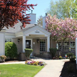 A charming house surrounded by blossoming trees and colorful landscaping.