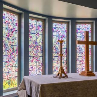 A serene church altar with stained glass windows in the background.