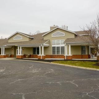 A suburban-style residential building with a spacious driveway and manicured surroundings.