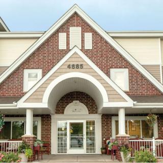 Front view of a building with a brick facade and arched entrance.