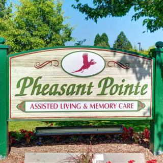 Sign for Pheasant Pointe, an assisted living and memory care facility, surrounded by trees.