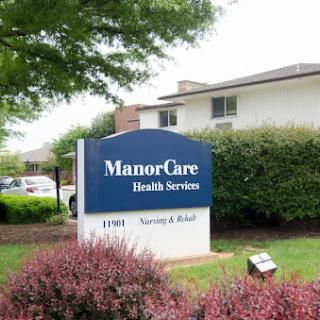 A sign indicating the location of ManorCare Health Services, set in a landscaped area.