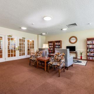 A cozy living room with comfortable seating, bookshelves, and a television.