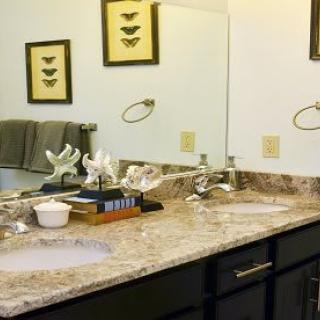 A neatly organized bathroom with a double sink and decorative elements on the countertop.