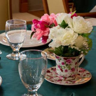 An elegant table setting featuring a floral centerpiece and sparkling glassware.