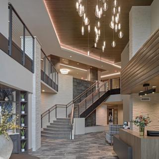 Modern lobby interior with staircase and contemporary lighting.