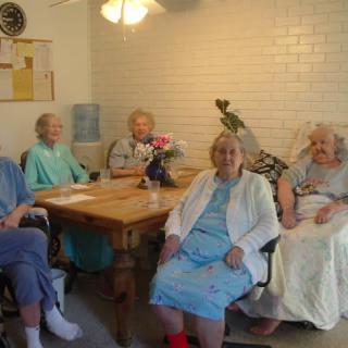 A group of elderly individuals sitting around a table indoors.