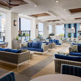 A modern lounge area with stylish blue-accented furniture and bright lighting.