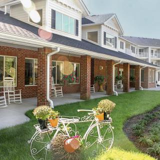 A charming retirement home with a beautifully landscaped garden featuring a decorative bicycle planter.