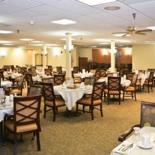 An empty dining room with neatly arranged tables and chairs, ready for guests.