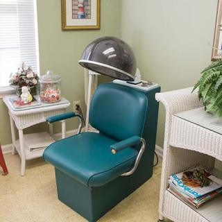 A vintage salon setup featuring a classic hair dryer and teal chair.