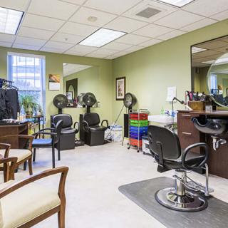 Interior view of a hair salon with chairs and salon equipment.
