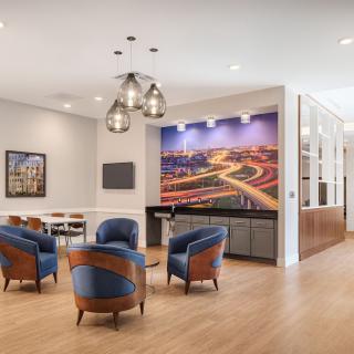 A modern lounge area featuring comfortable seating, contemporary artwork, and elegant lighting.
