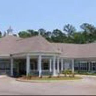 Front view of a commercial building with a large entrance and surrounding landscape.