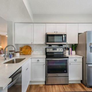Modern kitchen with white cabinetry and stainless steel appliances.