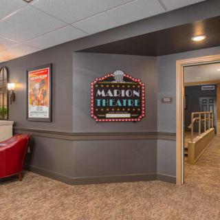 Interior of a movie theater with a classic marquee sign and vintage posters.