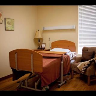 A typical hospital room with a bed and armchair, highlighting the healthcare setting.