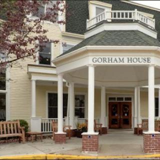 The inviting entrance of Gorham House, showcasing its architectural charm and outdoor seating area.