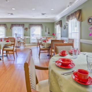 A neatly arranged dining room with tables set for a meal.