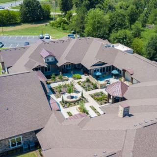 Aerial view of a building with a central courtyard surrounded by trees.
