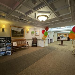 A spacious lobby decorated for an event, featuring seating and colorful balloons.
