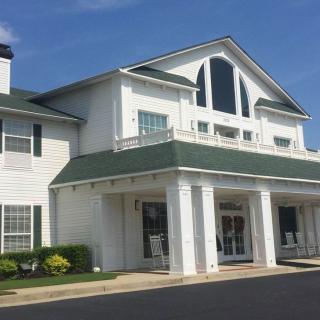 A traditional two-story building with a white exterior and gabled roof.