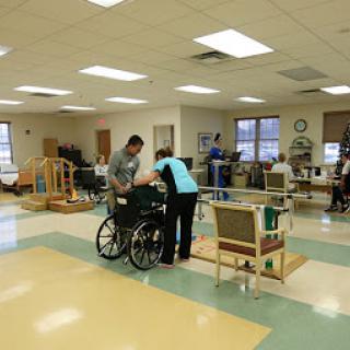A rehabilitation center where caregivers assist individuals in therapy activities.