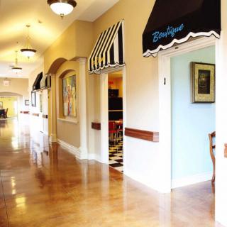 A brightly lit hallway with wooden flooring and decorative awnings over doorways.