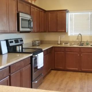 A modern kitchen with wooden cabinets and stainless steel appliances.