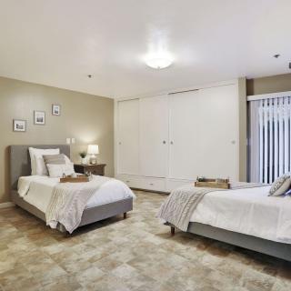 A modern bedroom with two twin beds featuring neutral colors and minimalist decor.