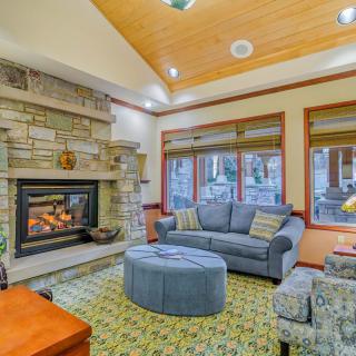A cozy living room with a stone fireplace and comfortable seating.