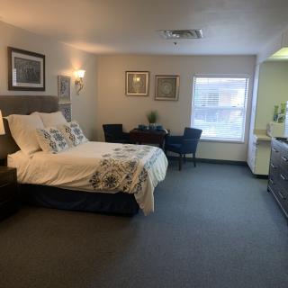 A spacious and well-decorated hotel room with a comfortable bed and seating area.