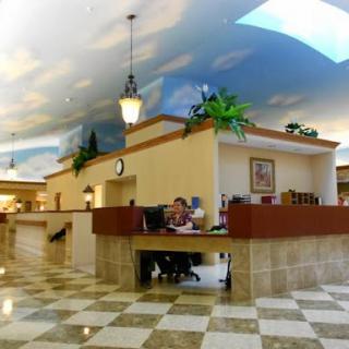 A spacious lobby featuring a decorative ceiling and modern furnishings.
