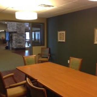A conference room with a wooden table and chairs, suitable for meetings.