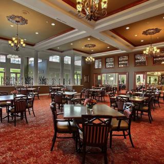 Spacious dining hall with elegant chandeliers and large windows.