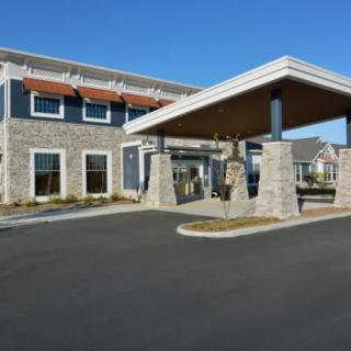 A modern building with a stone facade and covered entrance.