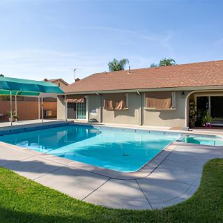 A residential backyard featuring a swimming pool and patio area.