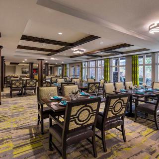 A modern dining area with elegantly arranged tables and chairs, featuring stylish decor and ambient lighting.